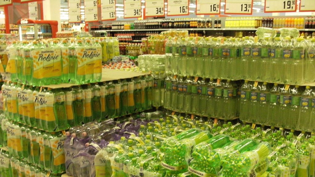 Od 1 stycznia 2027 wyższa akcyza, opłata cukrowa i VAT na napoje: ile zdrożeją wódka, piwo i energetyki Butelki napojów gazowanych na półce w supermarkecie